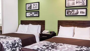 Ein Hotelzimmer mit zwei Betten, einer grünen Wand und gerahmten Bildern.