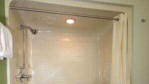 A walk-in shower with a grab bar, a shower curtain, and a tiled floor. - Sleep Inn Concord - Kannapolis (Concord)