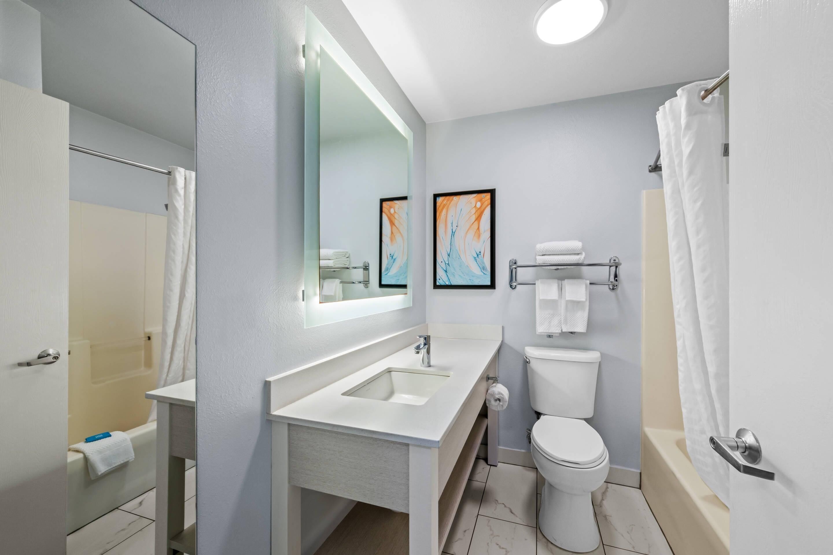 A modern bathroom with a sink, toilet, and shower.