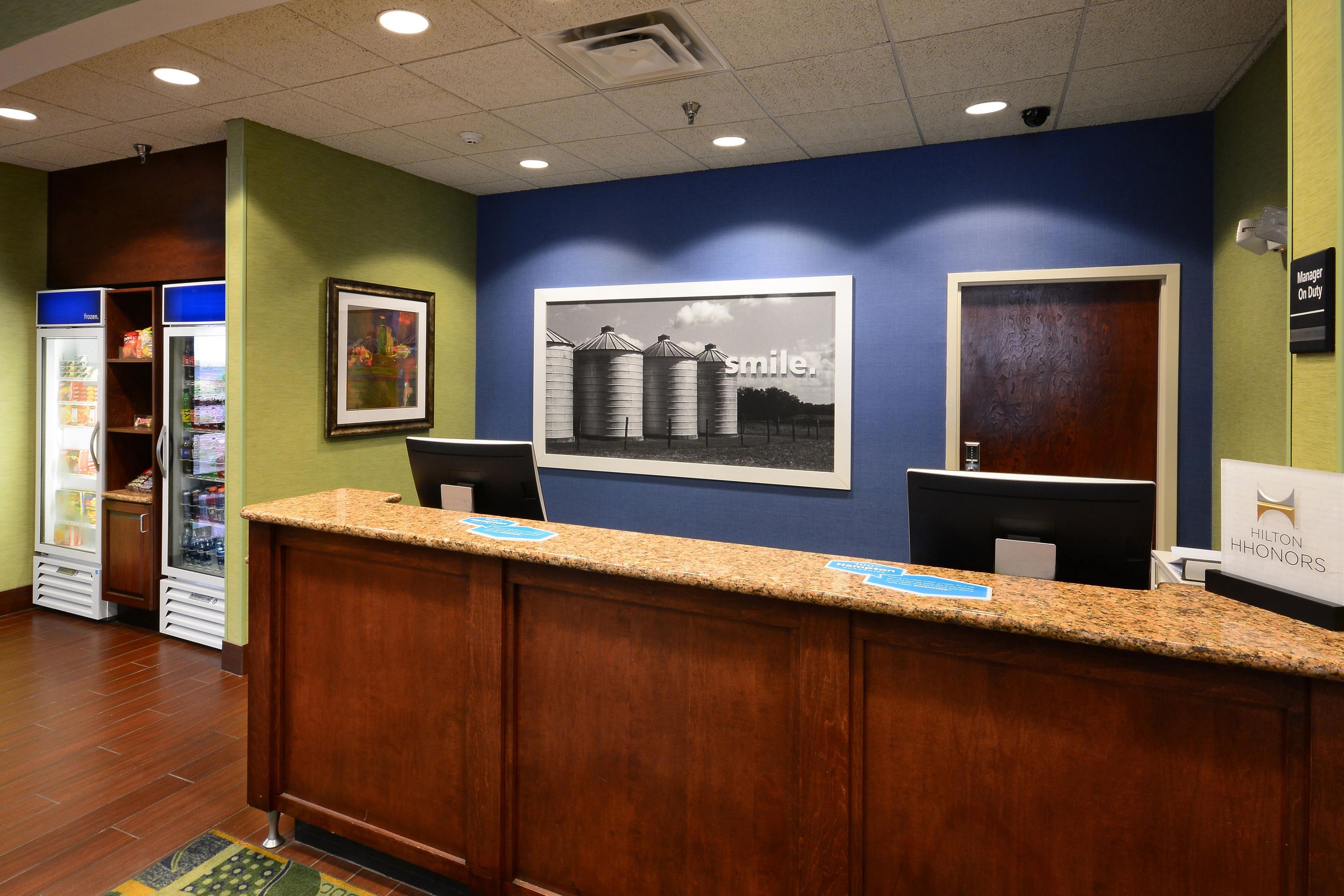 A hotel reception desk with a framed picture of silos and the word 'smile.'