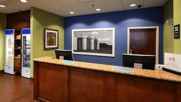 A hotel reception desk with a framed picture of silos and the word 'smile.'