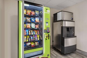 A vending machine with a green exterior and a water dispenser next to it. - Sleep Inn Hanes Mall (Winston-Salem)
