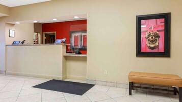 A reception area with a desk, a bench, and a framed artwork on the wall.
