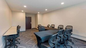 Une salle de conférence dotée d’une grande table et de chaises, d’un sol recouvert de moquette et d’un éclairage encastré au plafond.