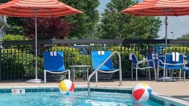 A swimming pool with lounge chairs and umbrellas. - Towneplace Suites By Marriott Cleveland Westlake (Westlake)