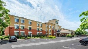 Ein mehrstöckiges Hotel mit Parkplatz davor.