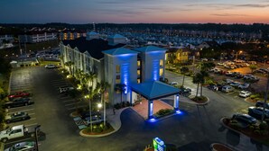 A hotel with a parking lot, a covered area, and a view of the surrounding neighborhood at dusk. - Holiday Inn Express N.Myrtle Beach- Little River by IHG (Little River)