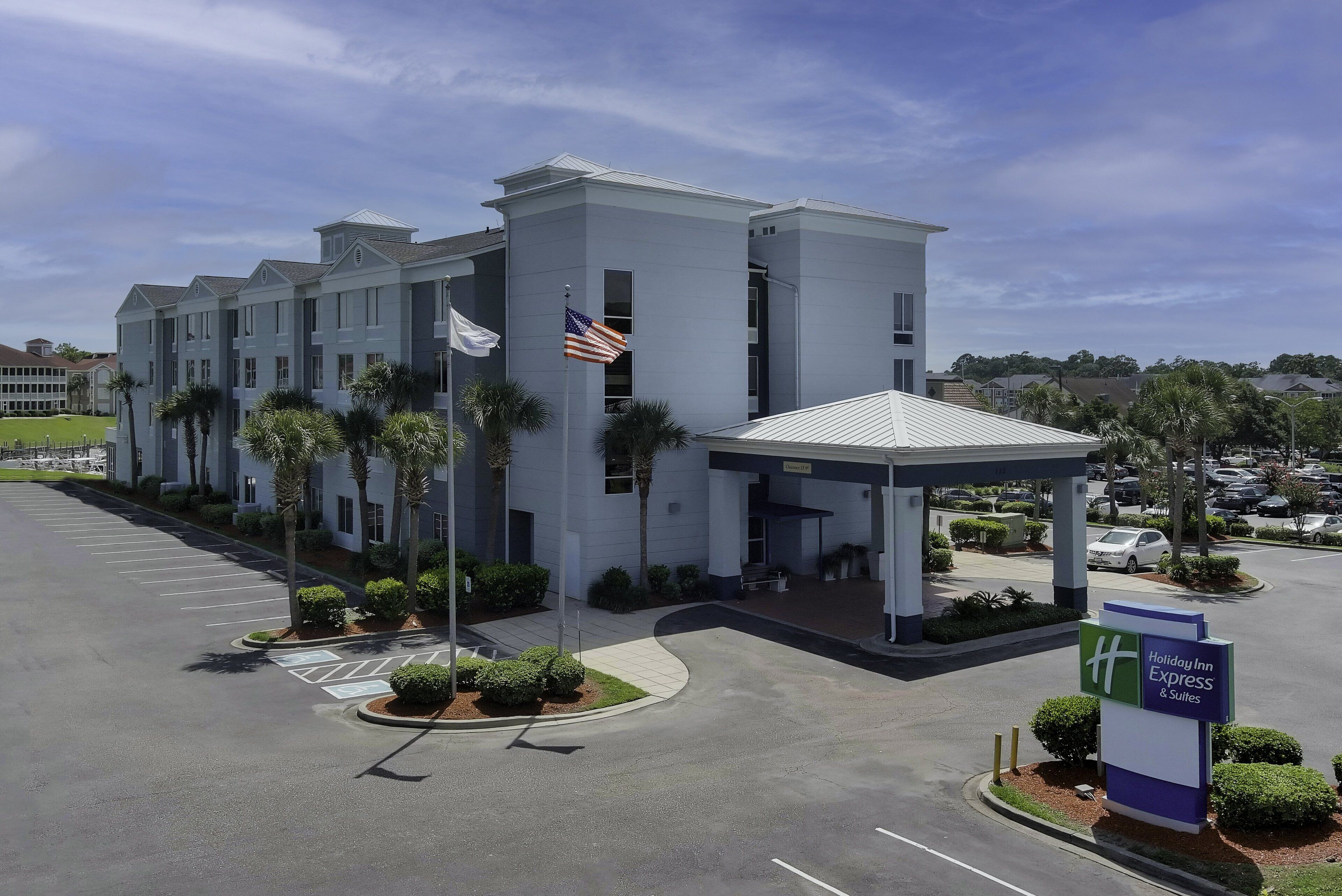 Edificio de Holiday Inn Express & Suites con estacionamiento y entrada cubierta.