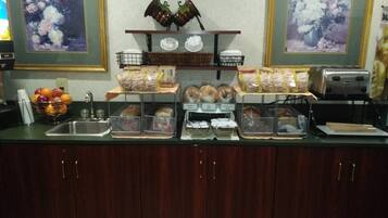 A buffet setup with various food items and a toaster.