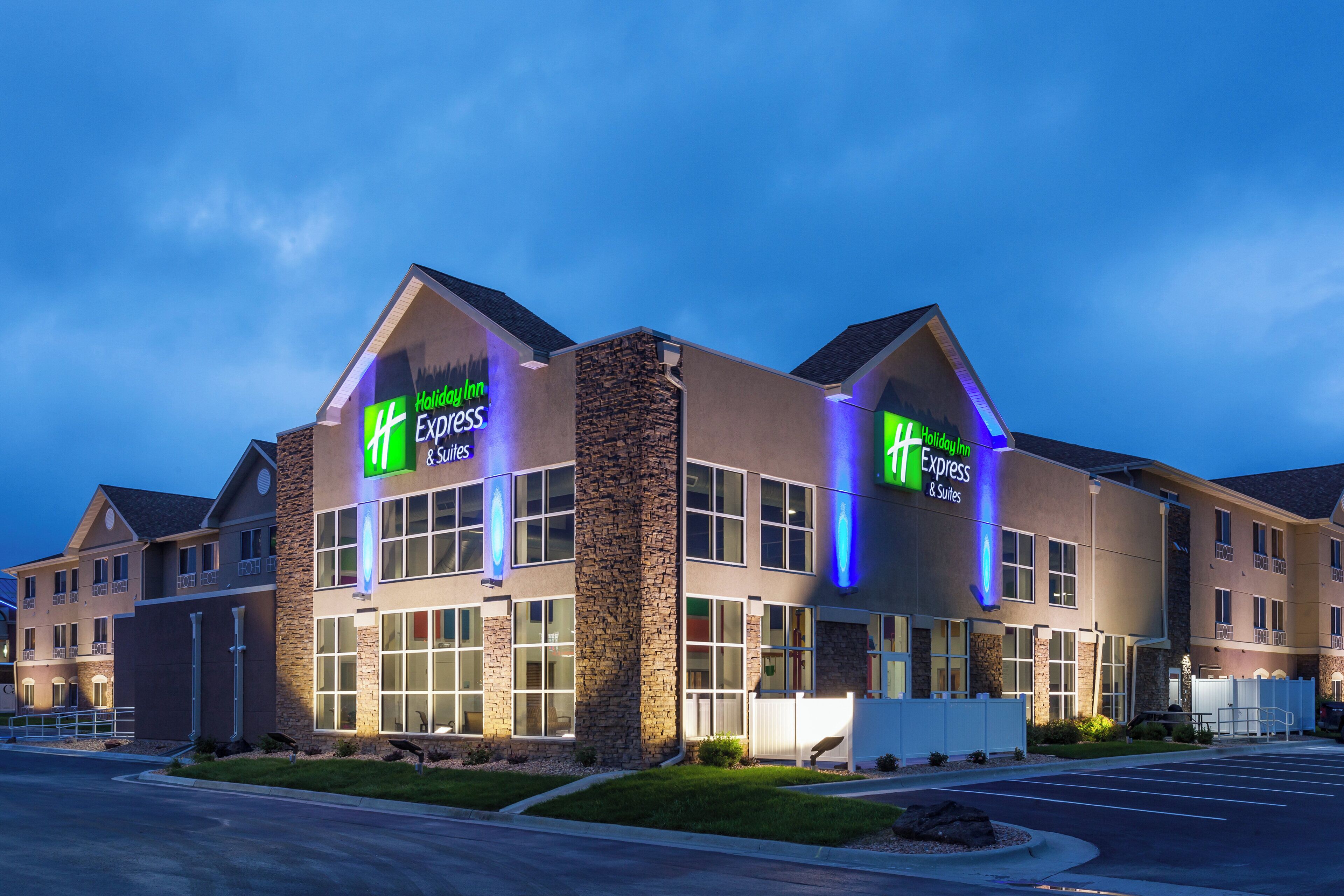A Holiday Inn Express hotel with a modern architectural design, featuring large windows and a stone facade.