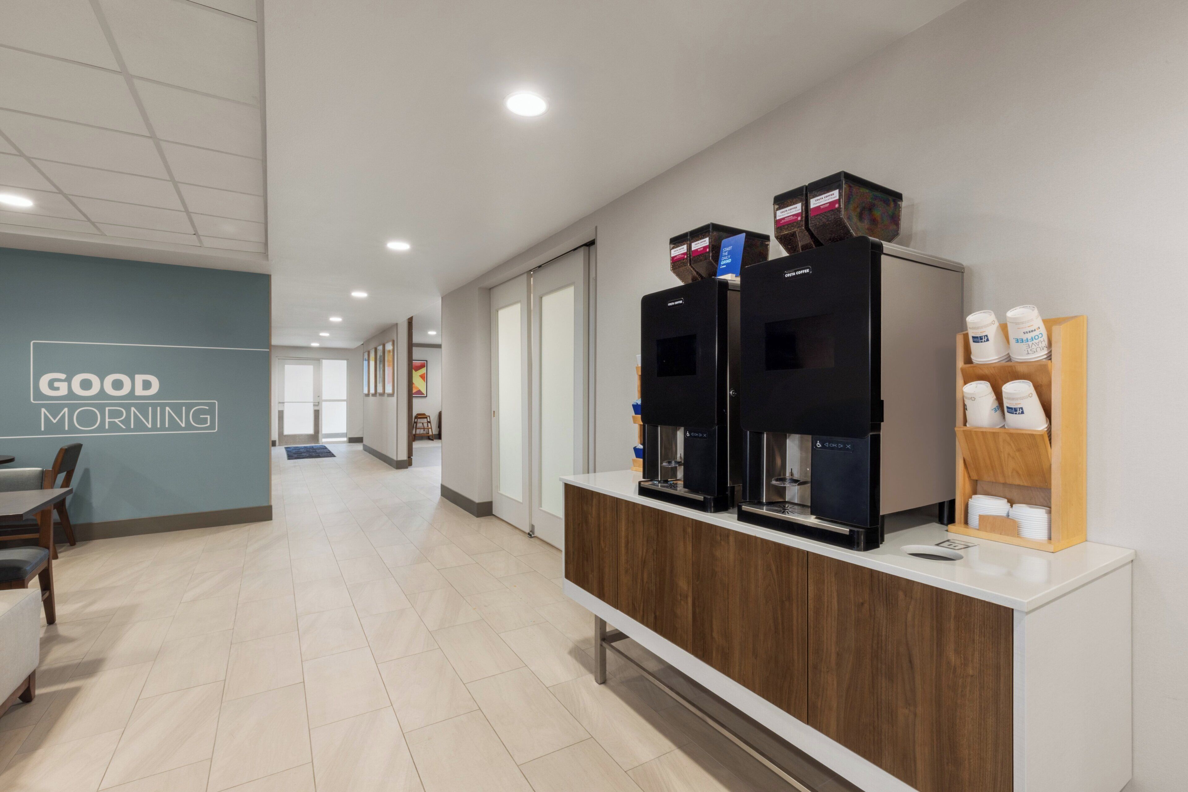 A modern coffee station with multiple coffee dispensers and a coffee grinder.