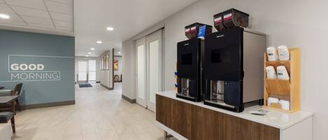 A modern coffee station with multiple coffee dispensers and a coffee grinder.