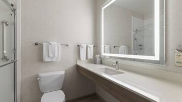 A modern bathroom with a toilet, sink, and shower.