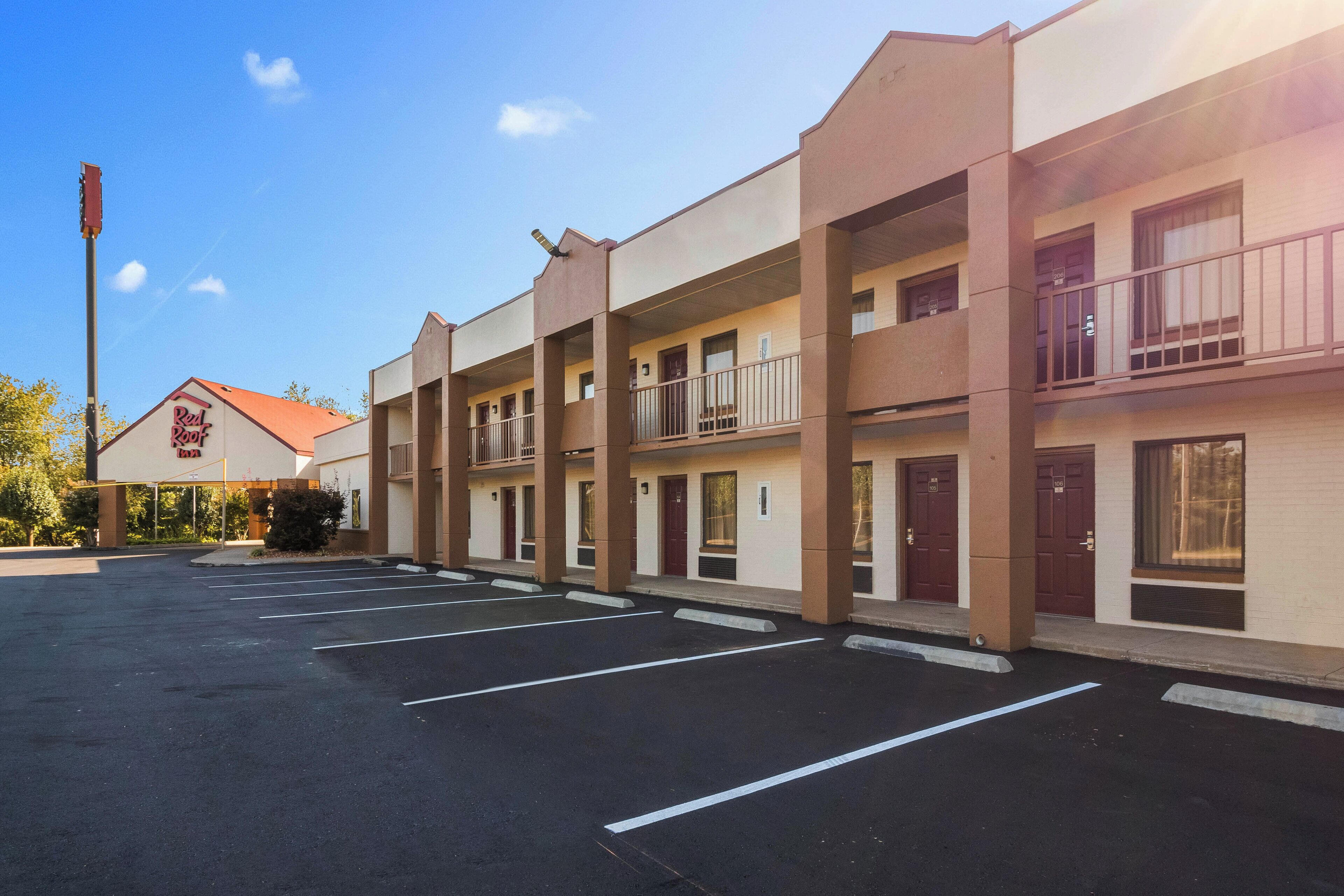A multi-story motel with a parking lot in front.