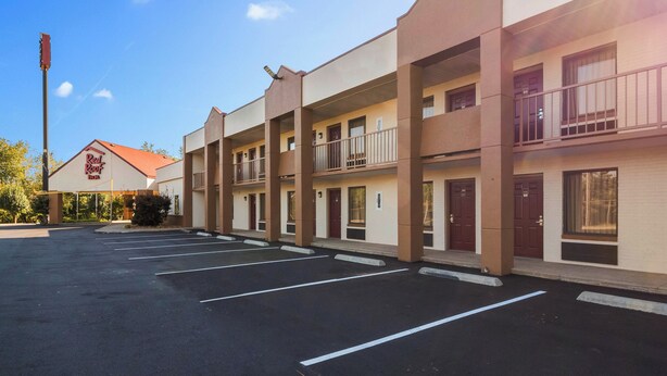 A multi-story motel with a parking lot in front. - Red Roof Inn Clarksville (Clarksville)