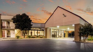 A building with a flat roof, a covered entrance, and a visible security camera. - Red Roof Inn Clarksville (Clarksville)