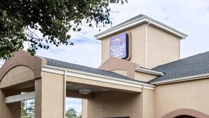 A Sleep Inn hotel with a beige facade, a prominent sign, and a covered entrance. - Sleep Inn Nashville Downtown Opryland Area (Nashville)