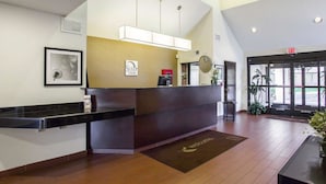 A hotel reception area with a reception desk, a clock, and a sign indicating the exit. - Sleep Inn Nashville Downtown Opryland Area (Nashville)