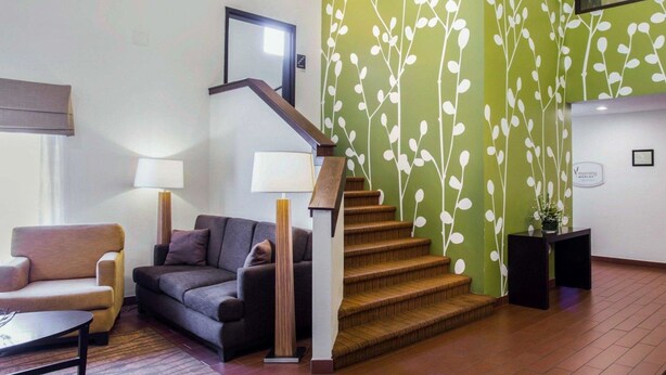 A modern living room with a staircase, a sofa, a coffee table, and a lamp. - Sleep Inn Nashville Downtown Opryland Area (Nashville)