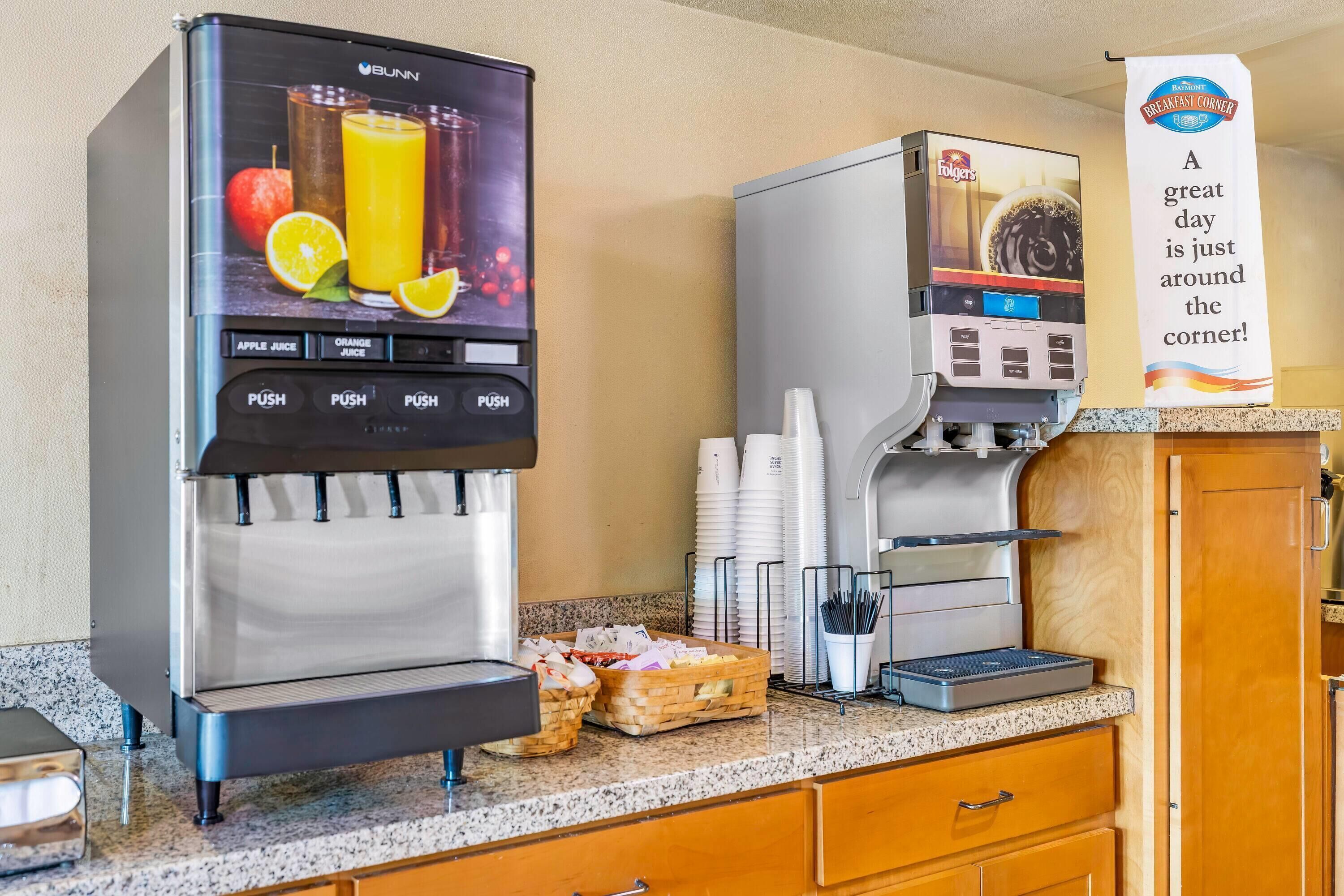 A self-service beverage station with options for apple juice and orange juice, and a coffee machine.
