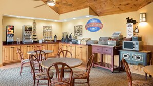 Un espace dédié au petit-déjeuner, avec des meubles de rangement en bois, une machine à café, un four à micro-ondes et une horloge murale.