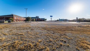 An empty parking lot with a building in the background. - Travelodge by Wyndham Decatur TX I-287 (Decatur)