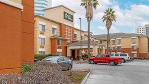 A hotel with a modern design, featuring a prominent sign for Star America. There are several vehicles parked in the lot, including a red pickup truck and a white SUV.
