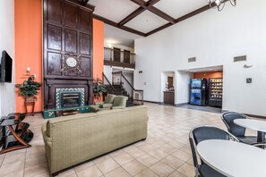 A spacious lobby with a fireplace, seating area, and vending machines.