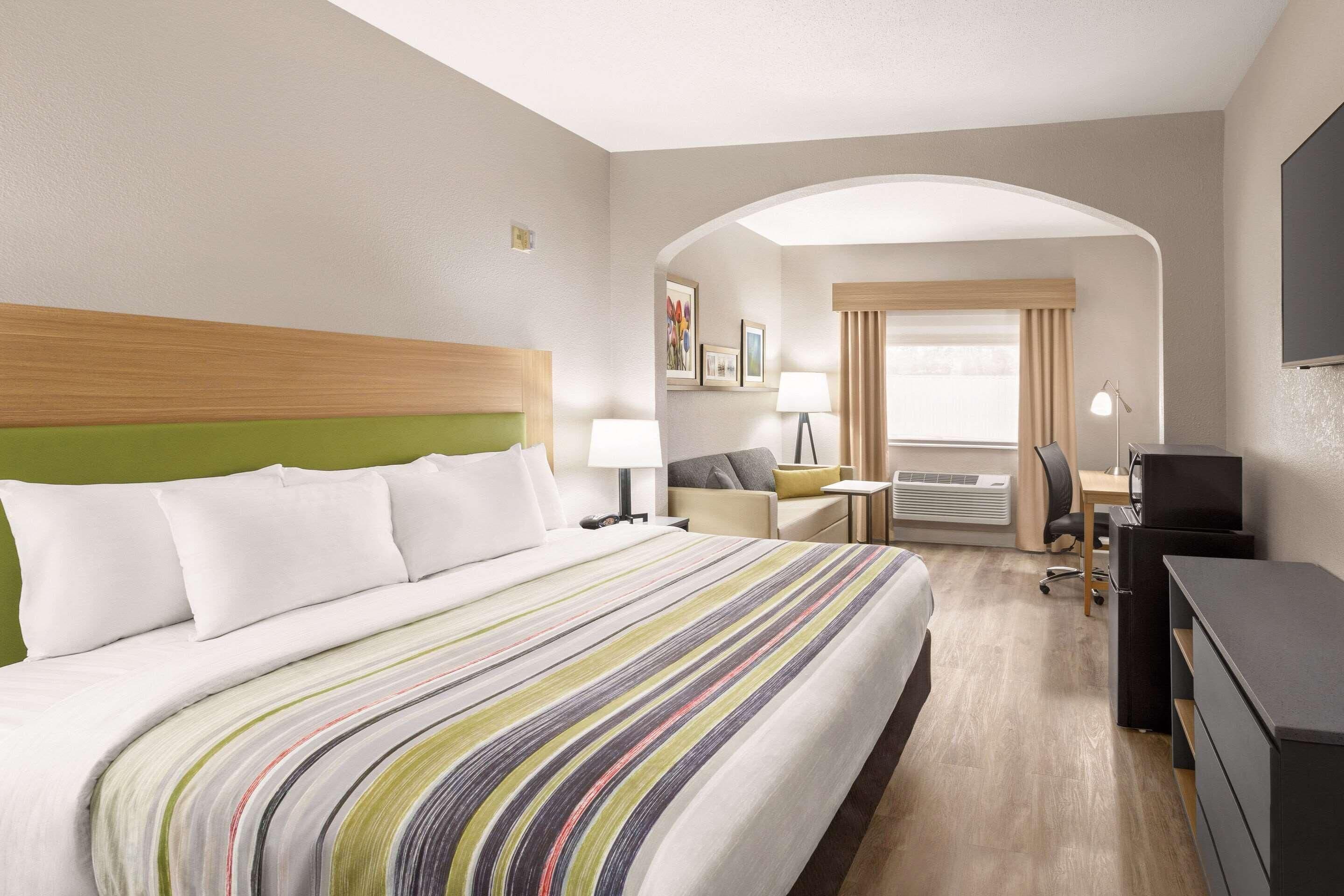 Een hotelkamer met een bed, bureau, stoel en een televisie.