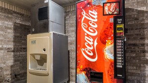 Máquina expendedora con logotipo de Coca-Cola y dispensador de hielo independiente.