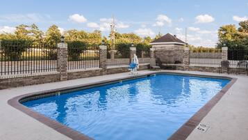 Una piscina al aire libre, sombrillas, sillones reclinables de piscina
