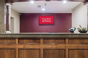 A reception desk with a sign indicating free Wi-Fi availability in all rooms.