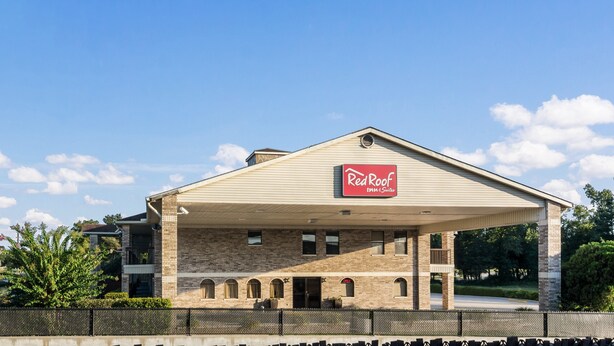 A Red Roof Inn & Suites building with a covered parking area and brick facade. - Red Roof Inn Conroe North - Willis (Willis)