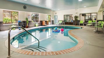 Piscina interna com superfície de água límpida, rodeada por um deck revestido de azulejos e uma borda de tijolos.