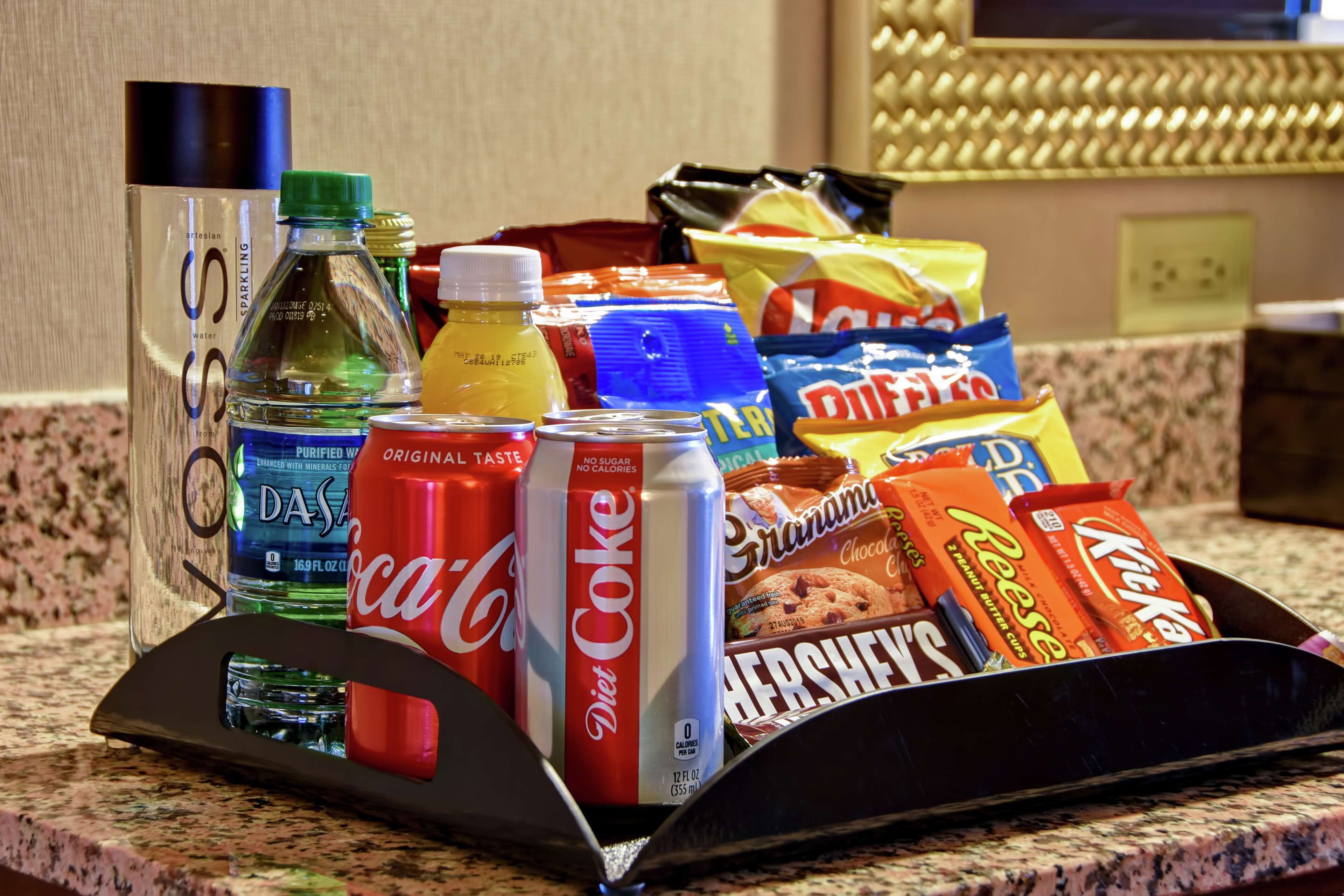 A tray with snacks and drinks on a kitchen counter.