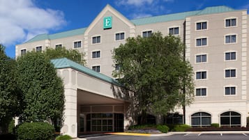 A multi-story hotel with a prominent 'E' logo, a covered entrance, and a parking lot.
