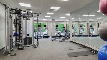 A gym with exercise equipment, mirrors, and exercise balls.