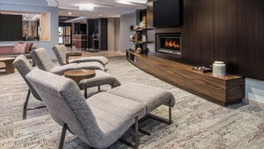 Ein modernes Wohnzimmer mit Kamin, Sofas und Fernseher.