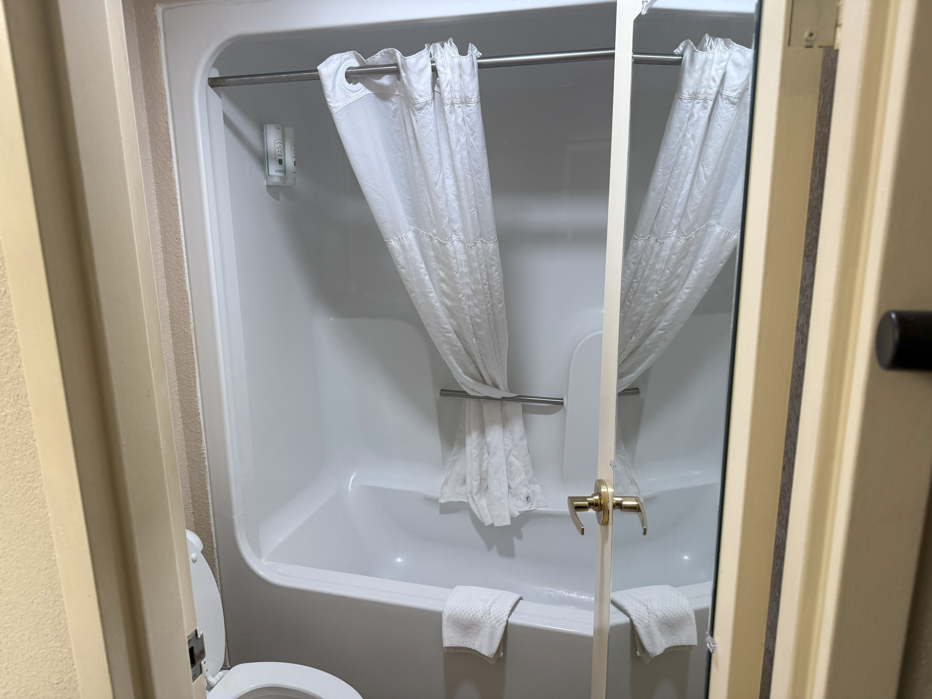 A bathroom with a bathtub, a toilet, and a shower curtain.