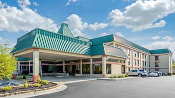 A hotel with a green roof, covered parking, and a landscaped entrance.