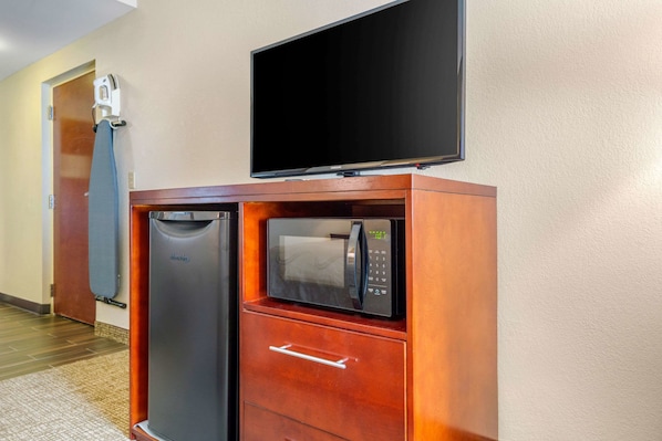 A compact kitchenette with a microwave, a small refrigerator, and a built-in oven.