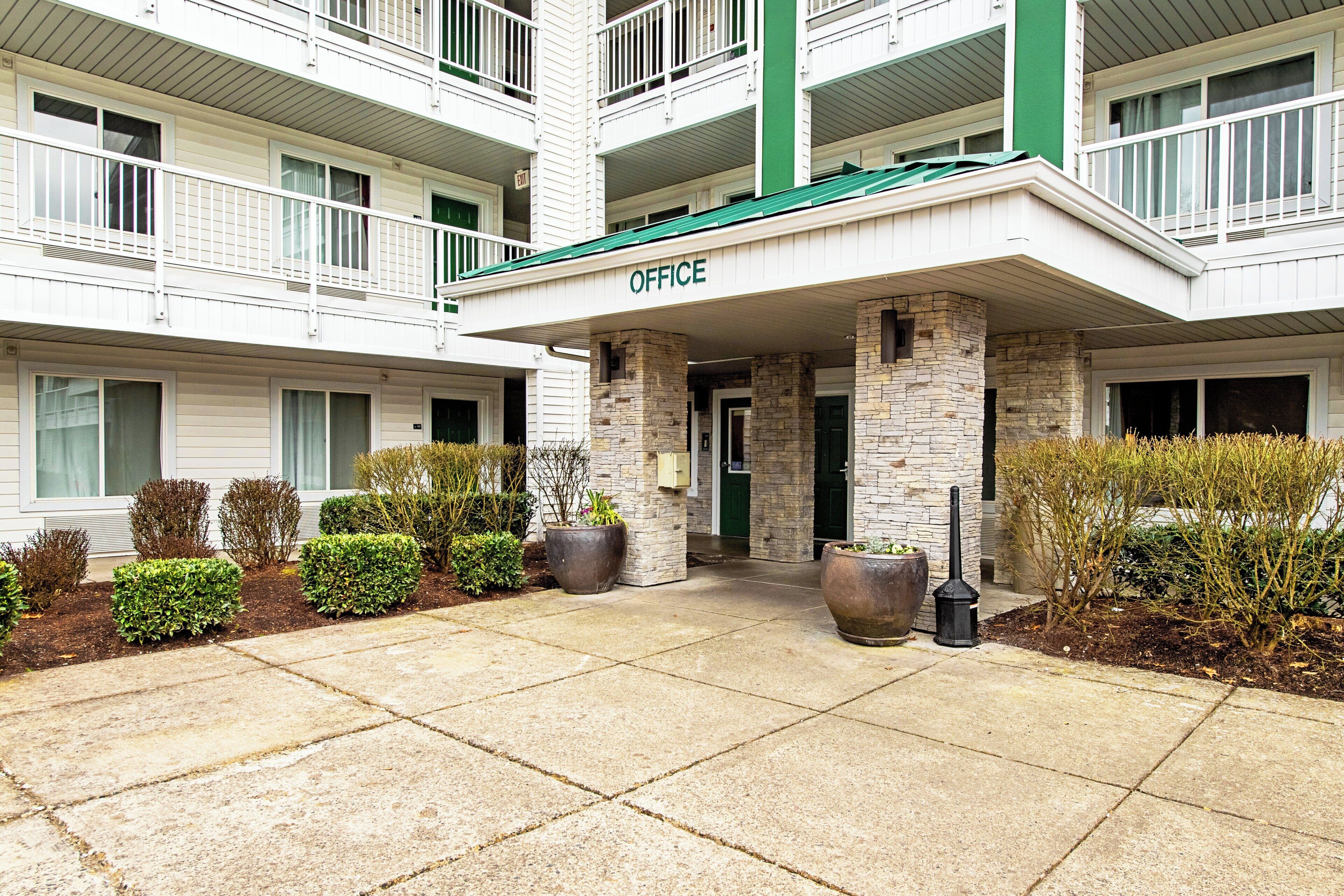 A multi-story building with a green awning labeled 'OFFICE' at the entrance.