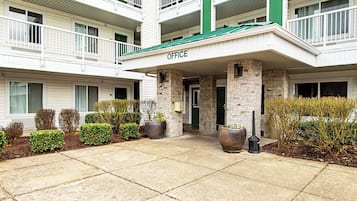 A multi-story building with a green awning labeled 'OFFICE' at the entrance.