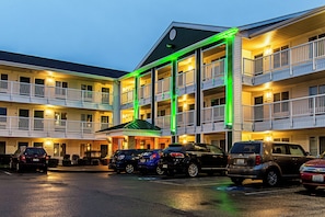 A multi-story hotel with a parking lot. - HomeTowne Studios by Red Roof Tacoma - Puyallup (Puyallup)