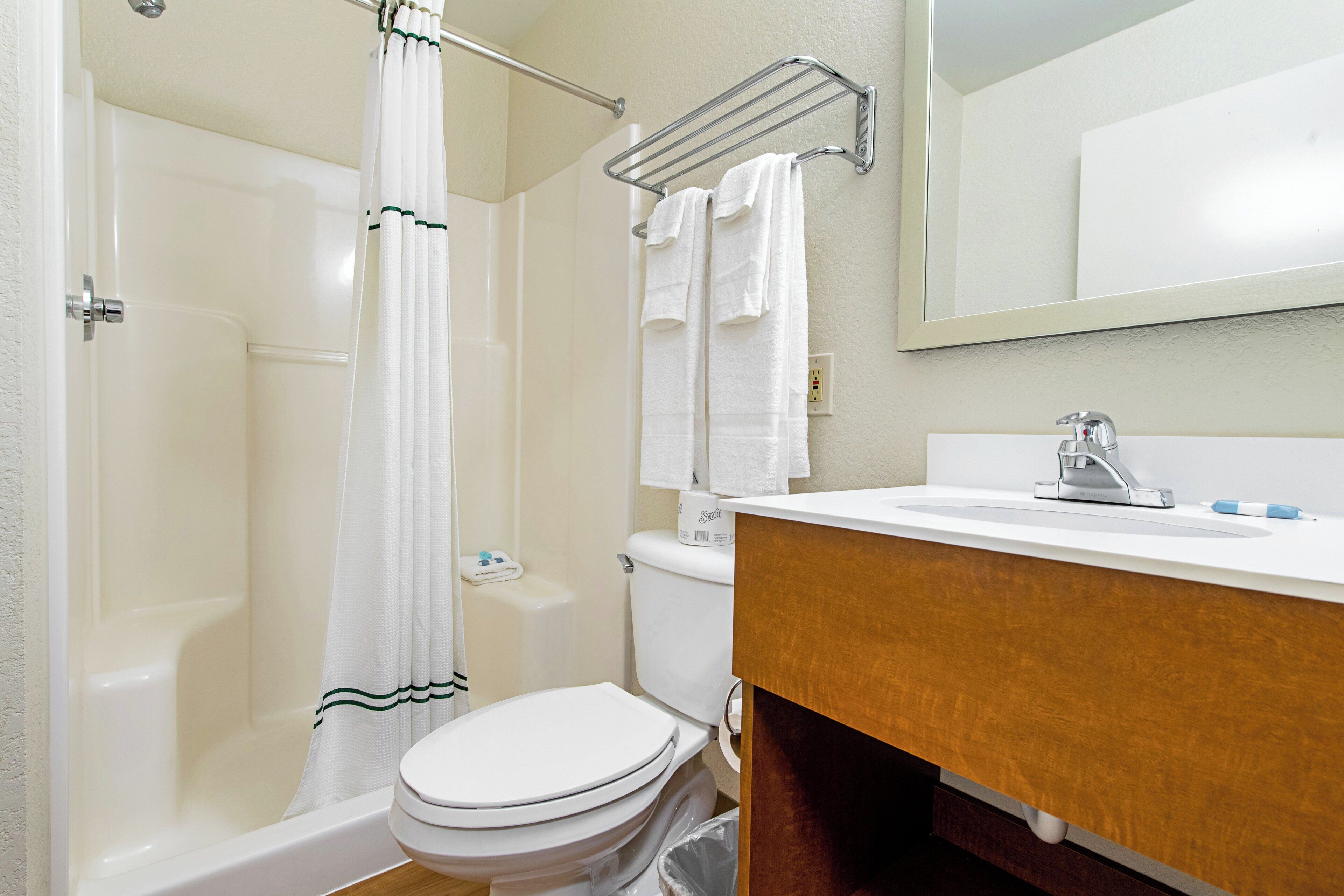 A bathroom with a bathtub, toilet, sink, and a mirror.