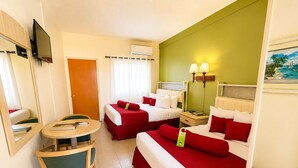 Une chambre d’hôtel avec deux lits, un bureau, une chaise, une télévision, une fenêtre avec des rideaux et un tableau au mur.