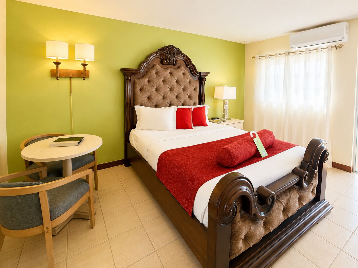 A hotel room with a bed, a bedside table, a chair, and a lamp.