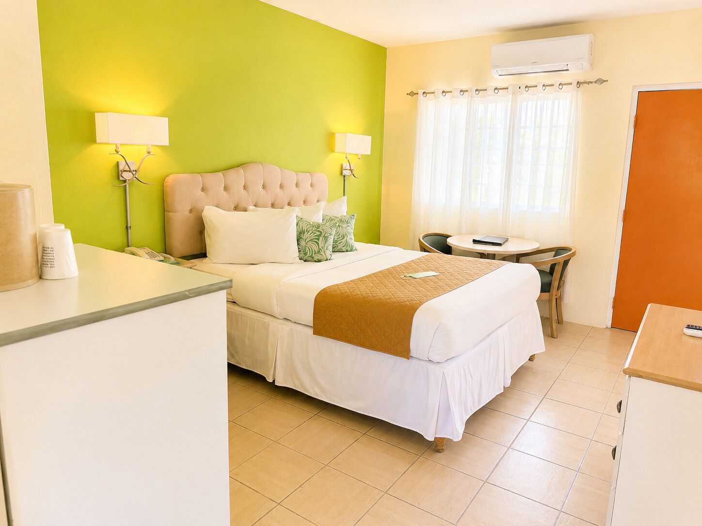 A hotel room with a bed, bedside lamps, a desk, and a chair.