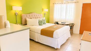 A hotel room with a bed, bedside lamps, a desk, and a chair.