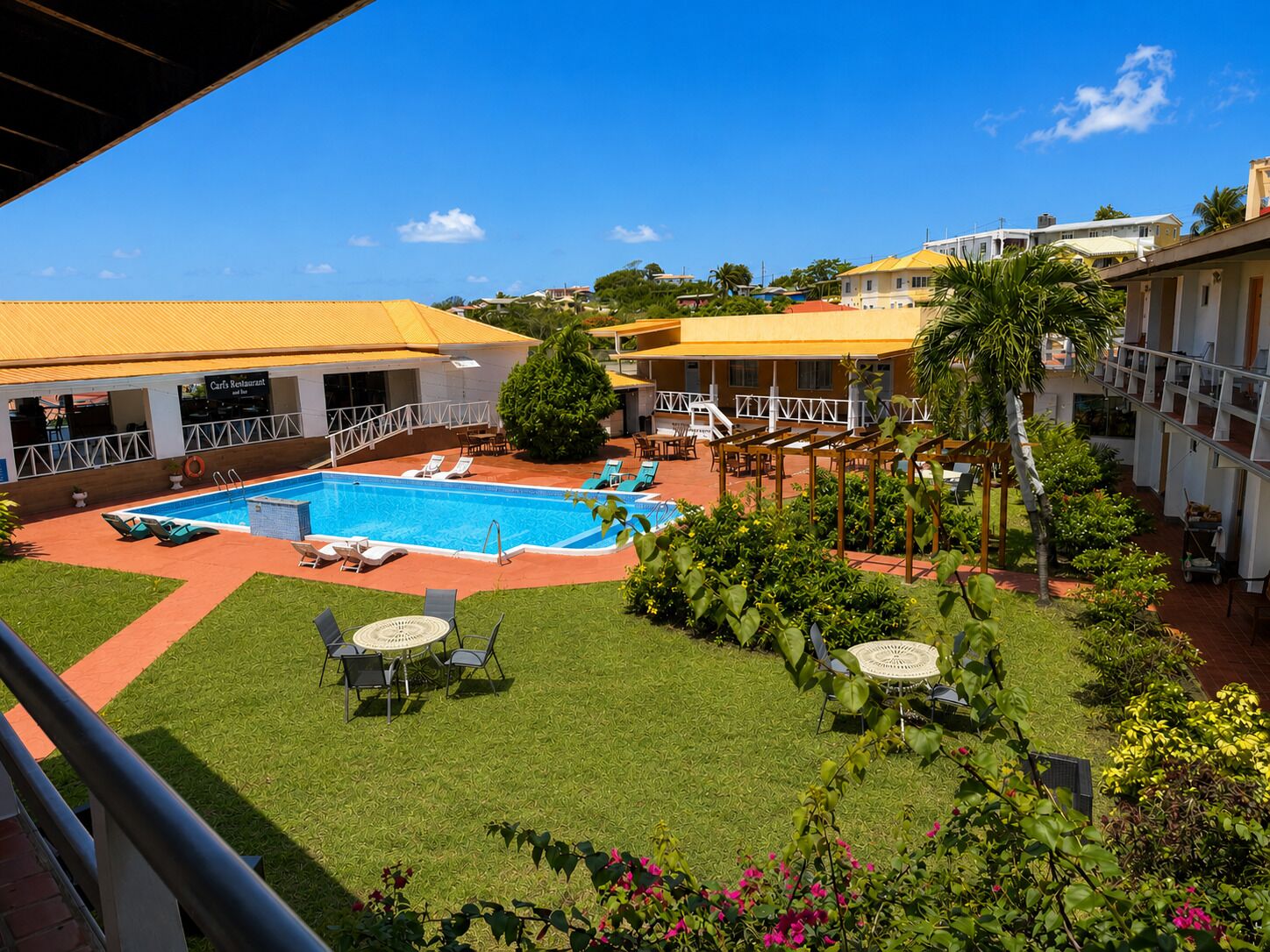 A hotel with a swimming pool, outdoor seating, and a restaurant.
